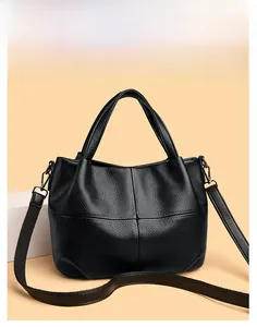 Close-up of litchi texture black leather tote with cross stitching and adjustable strap