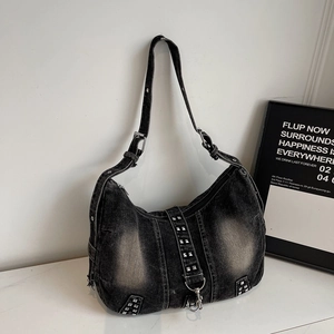 Grand sac demi-lune en denim gris avec clous argentés et bandoulière réglable sur blanc
