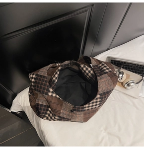 Detail view of spacious plaid tote bag interior with black lining and button closure
