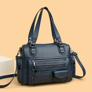 Detail of blue leather motorcycle bag with multi-zipper pockets and silver hardware