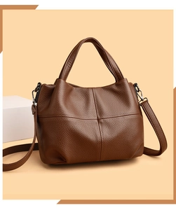 Detailed macro view of brown lychee grain leather texture and durable cross stitching
