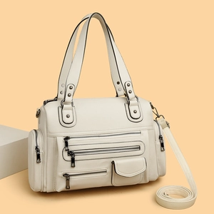 Chic cream leather multi-pocket moto bag with crossbody strap on minimalist studio background