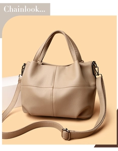 Close-up of beige lychee grain leather tote bag with cross stitching and hardware details