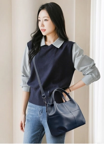 Close-up of deep blue litchi grain leather tote bag with cross-stitch and slim shoulder strap