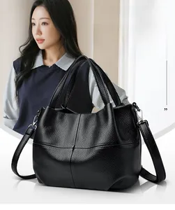 Detail of lychee pattern leather bucket bag with thick handle and adjustable strap