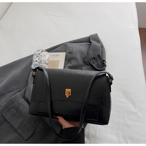 Détail du sac rétro noir avec texture plissée vintage et fermoir carré doré élégant