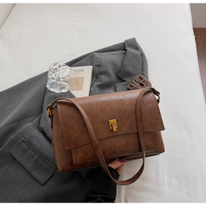 Détail du sac à main vintage marron avec fermoir doré et texture cuir vieilli
