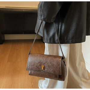 Détail du sac bandoulière rétro marron avec fermoir métallique vintage et texture simili cuir