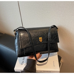 Détail d'un sac vintage en similicuir noir avec un fermoir rotatif doré élégant