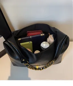 Detail view of spacious black quilted tote interior holding a tablet and essentials