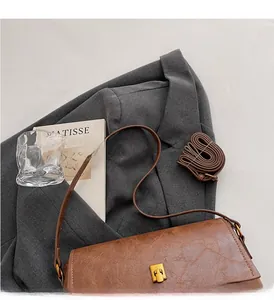 Vue détaillée d'un sac bandoulière vintage en cuir marron avec fermoir métallique
