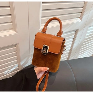 Detail view of brown vintage handbag featuring contrast textures and gold twist lock clasp