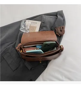 Vue détaillée du sac à bandoulière marron vintage avec compartiments intérieurs spacieux