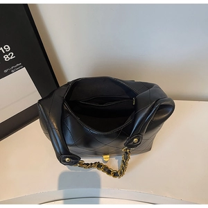 Top view of quilted black shoulder bag showing interior zipper pocket and gold chain