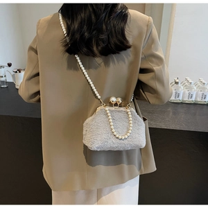 Détail du sac en peluche grise avec bandoulière perles et fermoir doré sur modèle