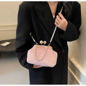 Détail du sac en fausse fourrure rose avec chaîne en perles et fermoir doré sur blazer