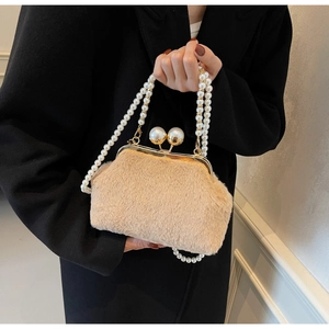 Détail du sac en peluche avec poignée en perles et fermoir en métal doré élégant