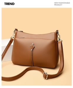 Detail of brown litchi pattern leather handbag with metal buckle and shoulder strap