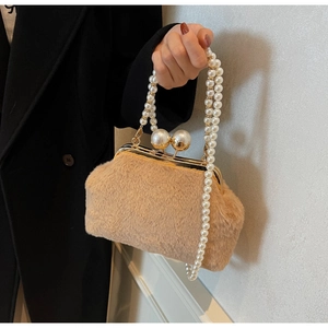Détail du sac coquillage en peluche avec cadre doré et fermoir perle décoratif