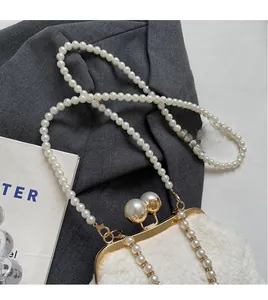 Gros plan du sac en fausse fourrure blanche avec cadre doré et bandoulière en perles