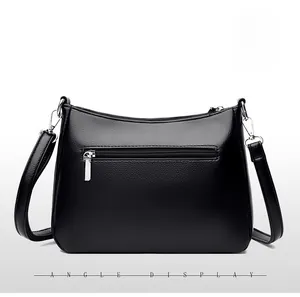 Detail view of the black crossbody bag back with silver zipper and lychee texture