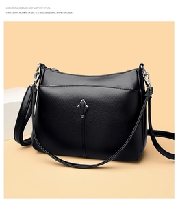 Detail of black lychee grain leather texture with silver metal buckle on a shoulder bag