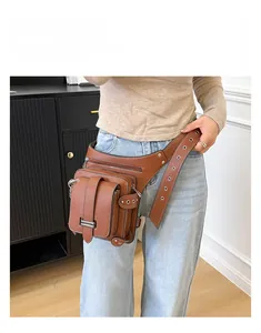 Detailed view of brown litchi texture leather waist bag with multiple zip pockets