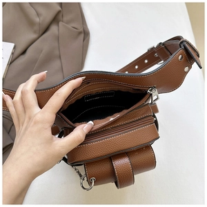 Macro shot of brown pebble grain leather waist bag showing silver zipper and interior detail