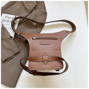 Close-up of brown litchi pattern leather waist bag with silver rivets and metal zipper