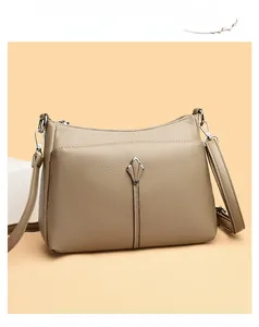 Detail of khaki pebbled leather texture and silver petal metal accessory on handbag