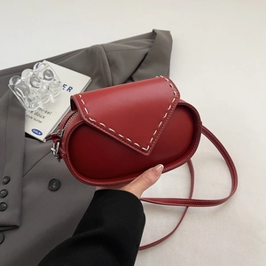 Red leather oval crossbody bag with contrast stitching and silver zipper closure
