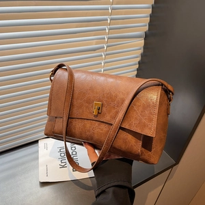Sac bandoulière rétro en similicuir marron avec fermoir en bronze et jeux de lumière