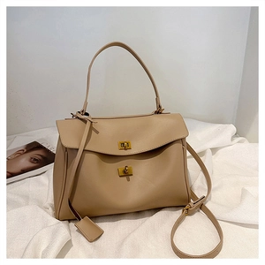 Detailed view of beige tote bag featuring double vintage gold twist-lock closures