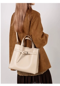 Detailed view of cream leather tote bag with knot buckle and silver metal accents