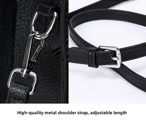 Detail of black lychee leather texture with silver metal hook and adjustable buckle strap