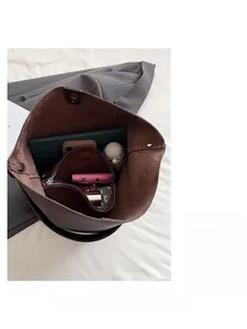 Dettaglio interno della borsa tote in pelle marrone con spazio per tablet e accessori