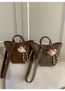 Détails de la texture litchi sur des sacs à main en similicuir marron et taupe chic