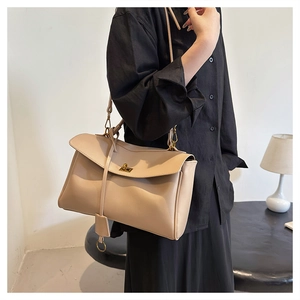 Detailed close-up of beige faux leather shoulder bag with a gold metal twist lock buckle