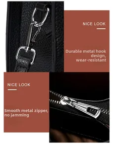 Detail of durable silver hooks and smooth metal zippers on black lychee grain leather bag