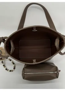 Vue de dessus de l'intérieur spacieux du sac seau en cuir marron avec sa pochette assortie