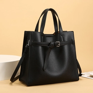 Close-up of black lychee grain leather tote bag with decorative strap and dual handles