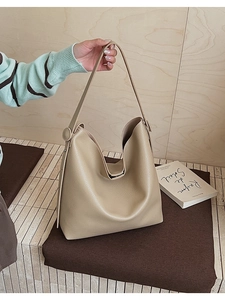 Dettaglio della borsa hobo in pelle beige testurizzata con fibbia circolare distintiva