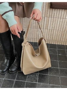 Dettaglio della trama in pelle martellata beige su una borsa a tracolla hobo minimalista