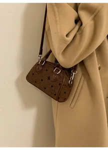 Detail of dark brown bow print Boston bag with leather straps and silver hardware