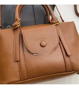 Détail du sac en cuir grainé caramel avec rabat et anneaux métalliques dorés élégants