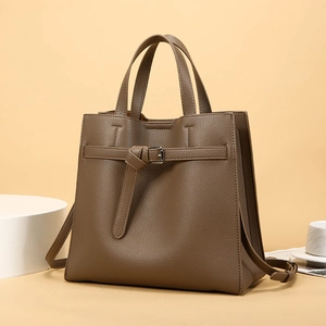 Detail of dark brown lychee textured leather tote bag with silver buckle and shoulder strap