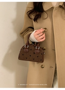 Close-up of brown polka dot wool handbag with bow embroidery and leather handle