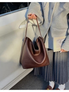 Dettaglio della pelle marrone scuro con trama litchi di questa borsa a secchiello casual