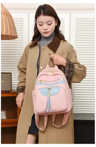 Close-up of pink litchi leather texture with blue flap and gold zipper on a backpack