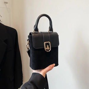 Minimalist black suede and smooth leather shoulder bag with rectangular gold buckle clasp